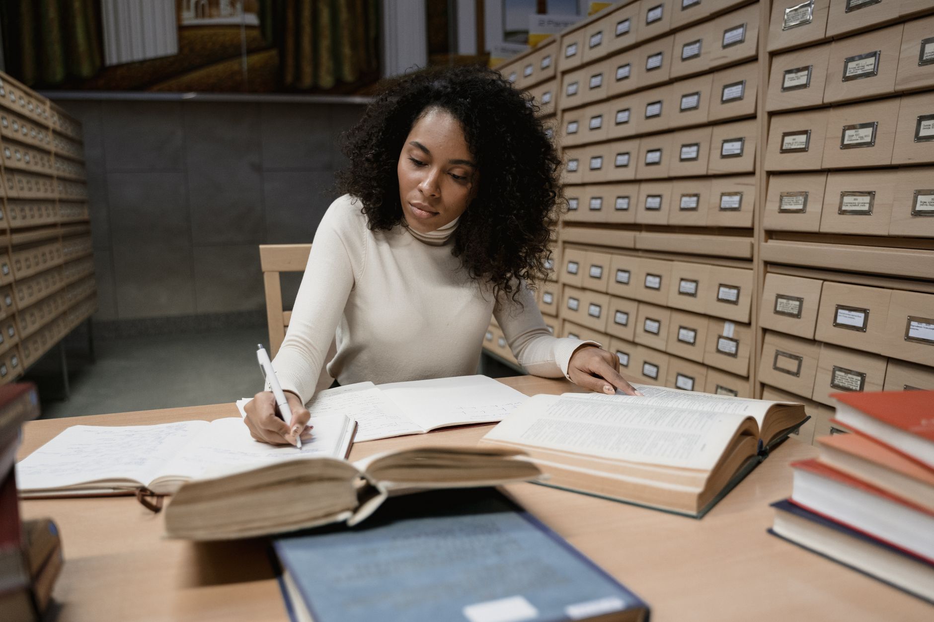 woman in a white long sleeves writing notes